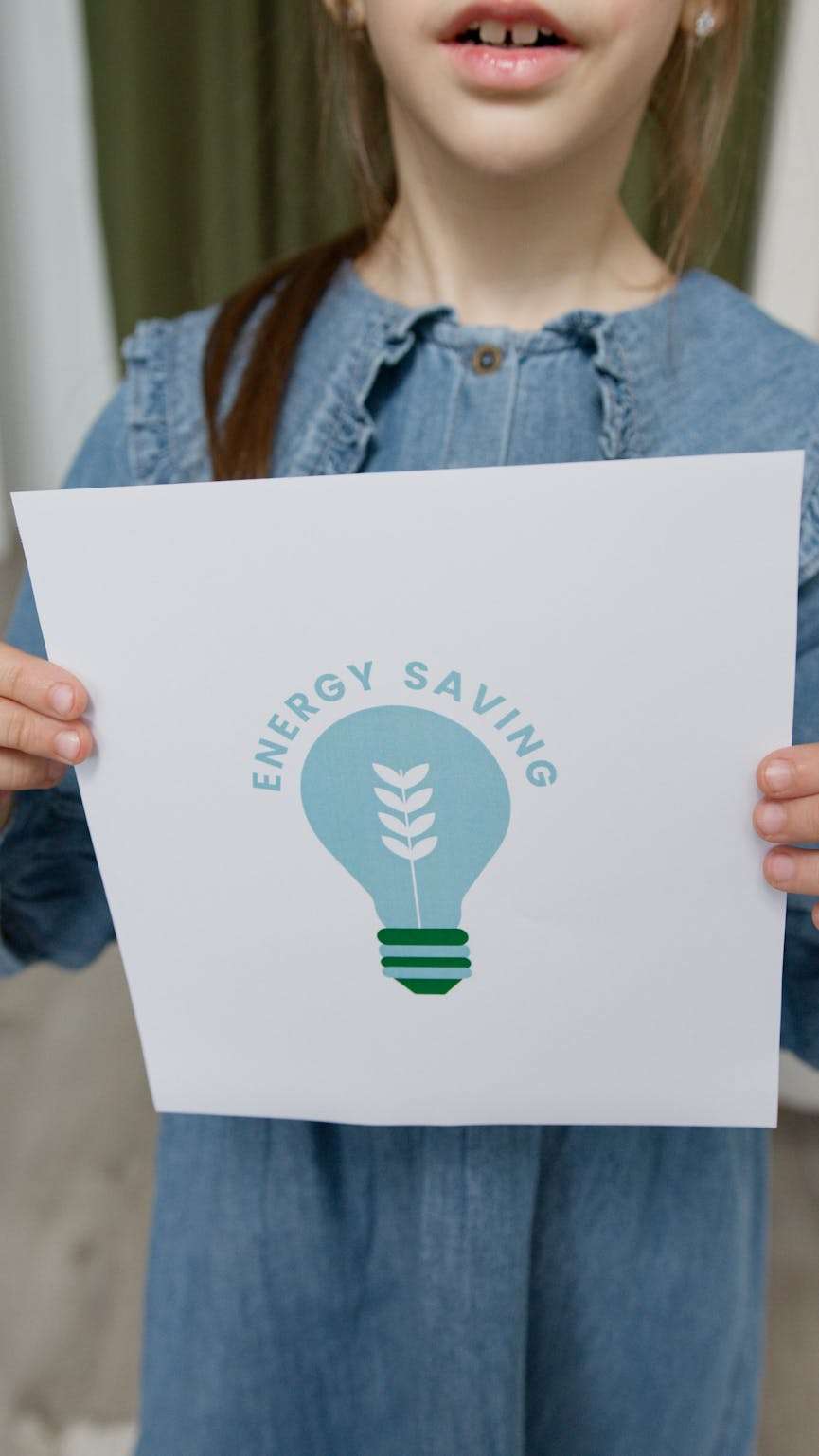 meisje die een afbeelding vast houdt waarop staat "saving energy"